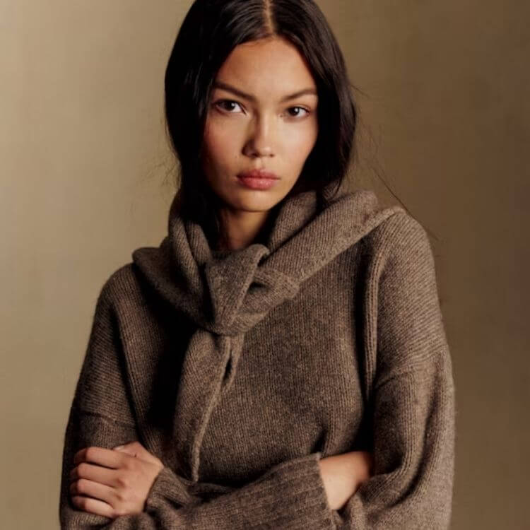 A thick knit scarf with long, chunky fringe at the ends.