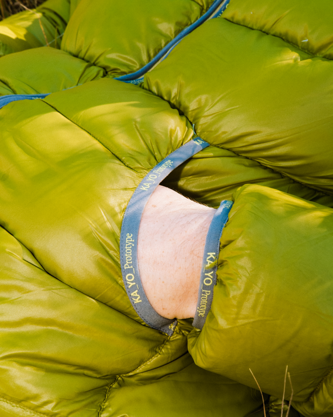 Close-up of a bright green puffer garment labeled KA_YO Prototype.