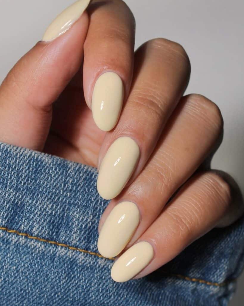 Detailed nail art with butter yellow and decorative textures.