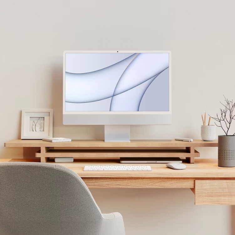 A wooden monitor riser elevating a screen on a modern desk.