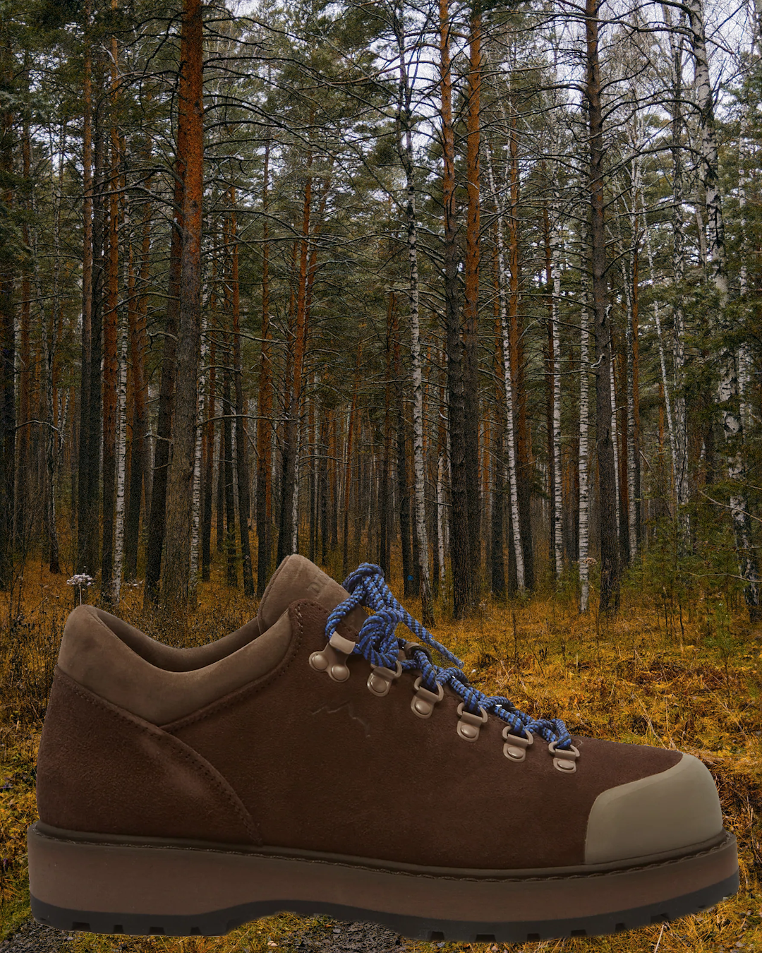 A person walking through a misty city park wearing technical low-top hikers and a rain shell.
