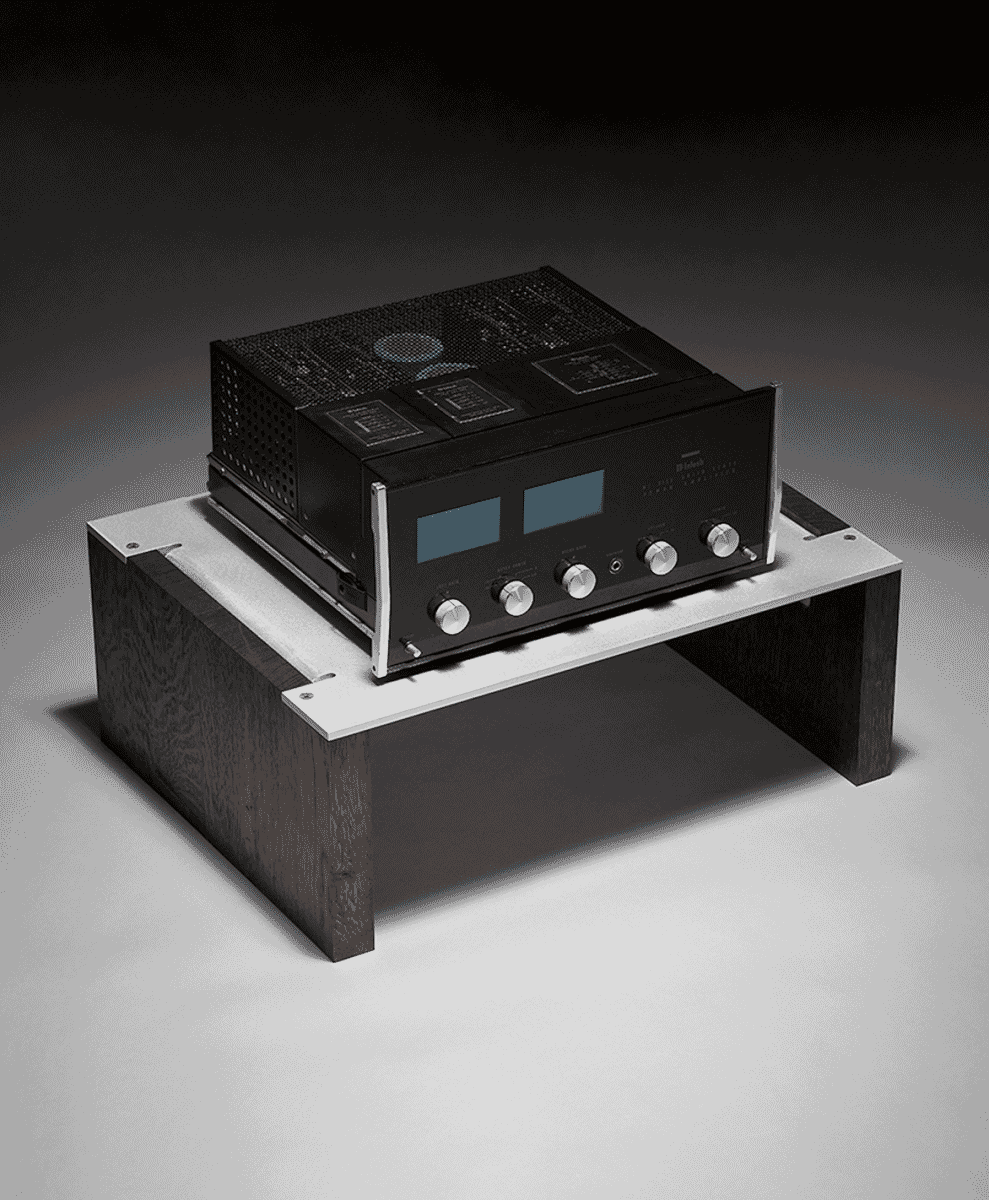 A vintage McIntosh amplifier on a modern wood and metal audio stand.