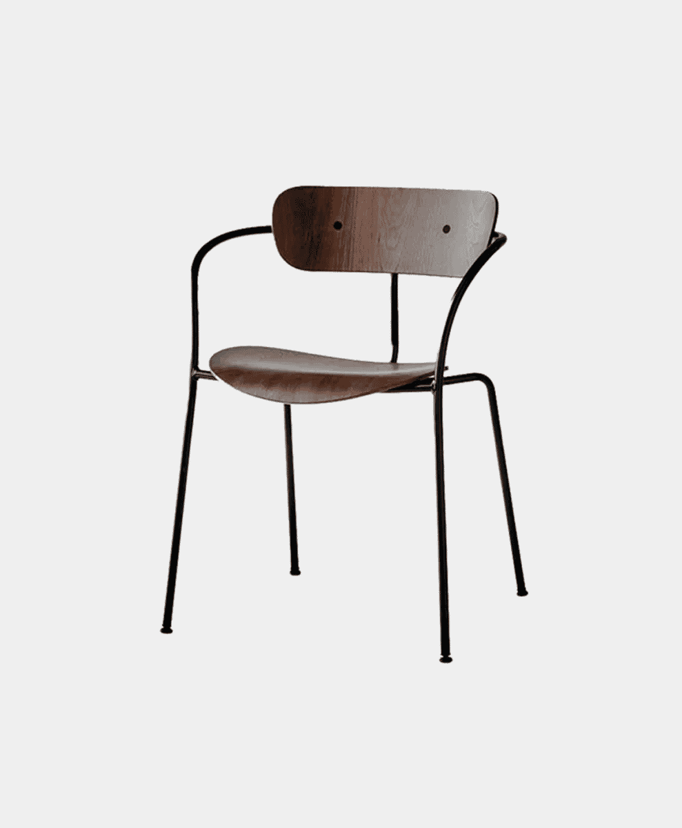 A modern &Tradition Pavilion chair featuring a black metal frame and curved walnut wood.