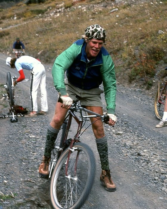 Long shot of a silhouette wearing Nike ACG gear standing on a cliff edge in Moab during a golden-hour sunset.