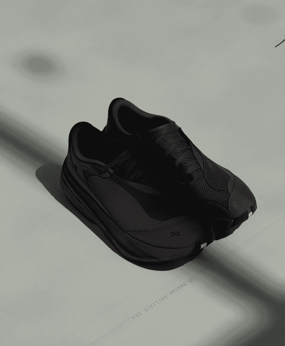 Top-down view of all-black technical athletic sneakers with mesh and synthetic overlays.