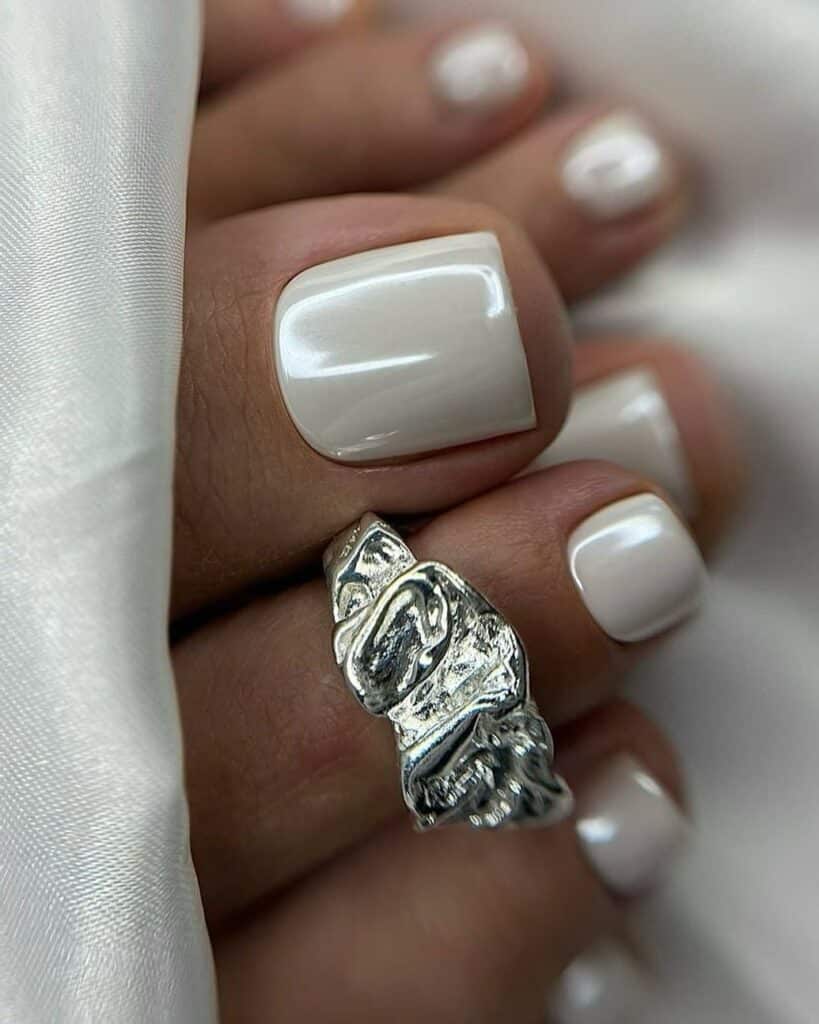 White chrome toe nails with high-shine reflective particles.