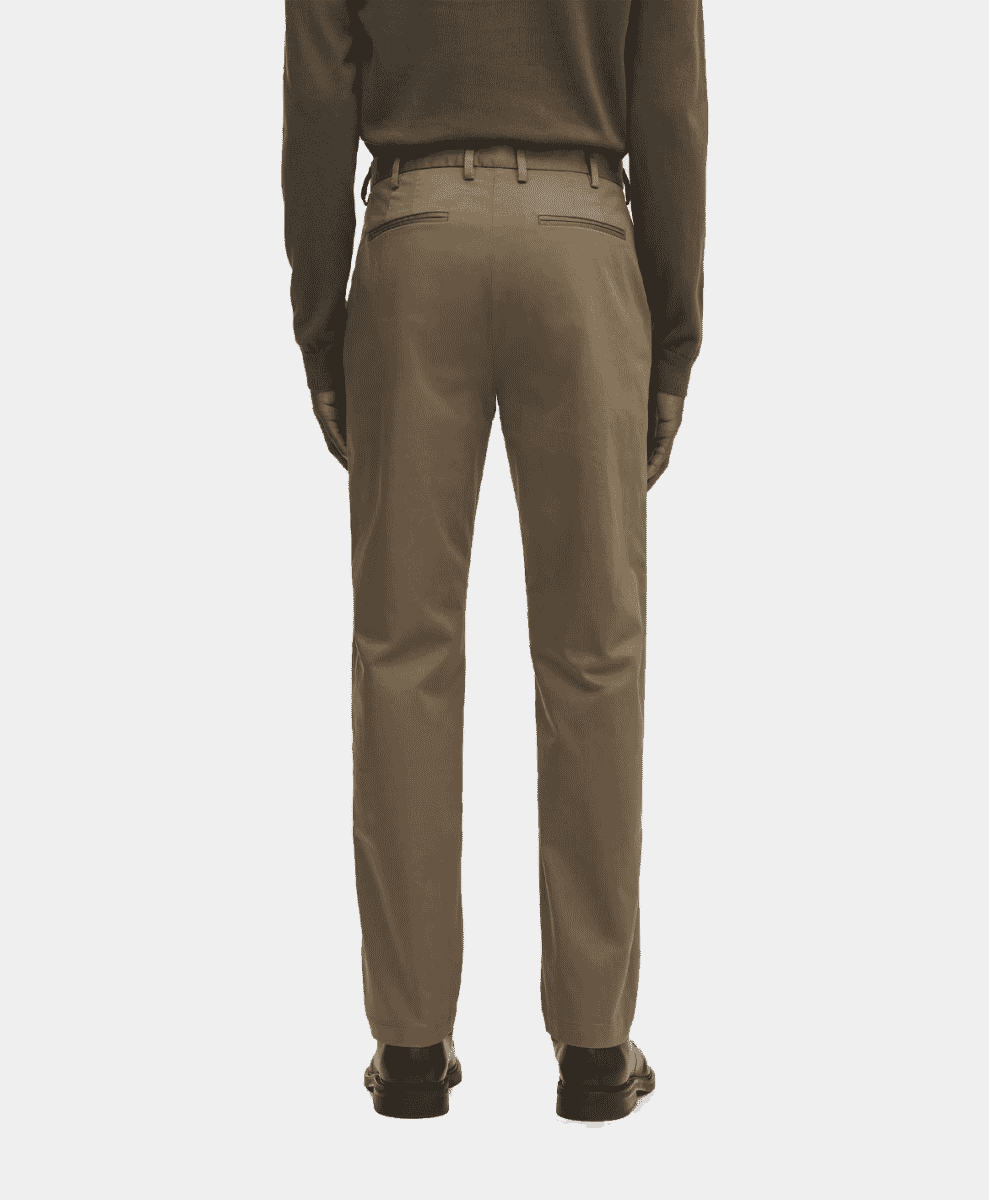 Back view of a man wearing well-fitted beige chinos and black dress shoes.