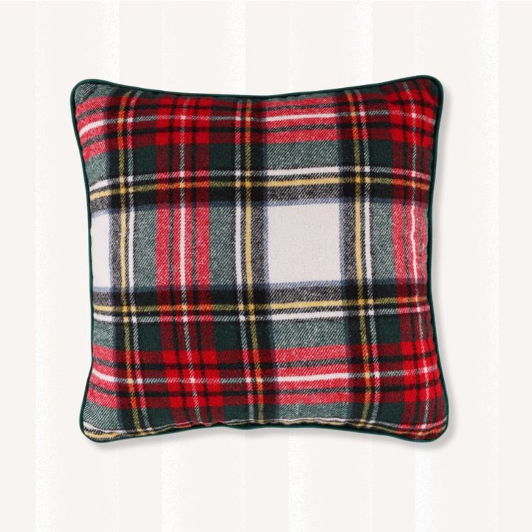 A red and green plaid throw pillow on a chair.