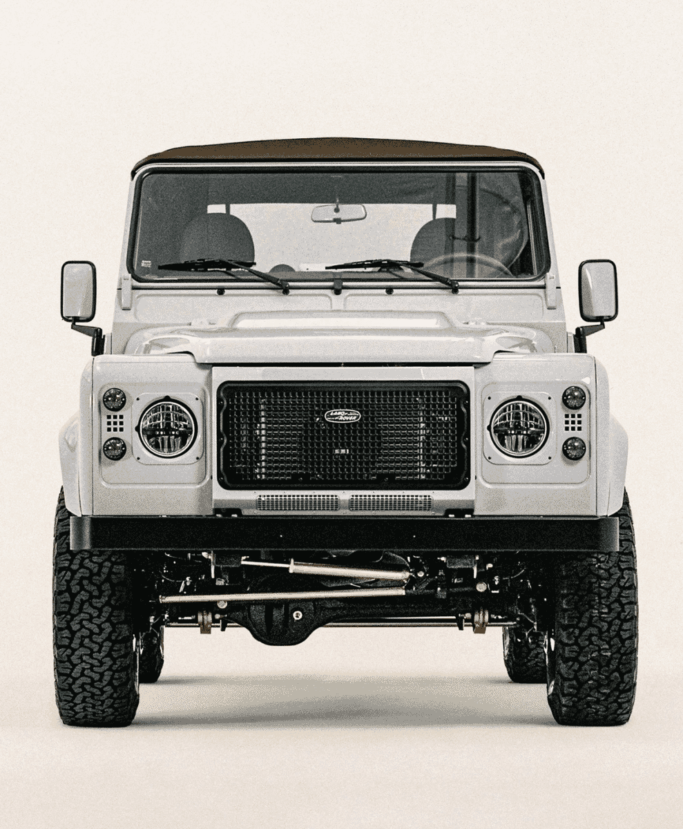 Front view of a white Land Rover Defender 90 showing the black grille and off-road tires.
