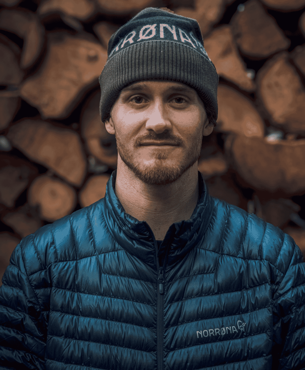 A man in a blue quilted Norrøna puffer jacket.