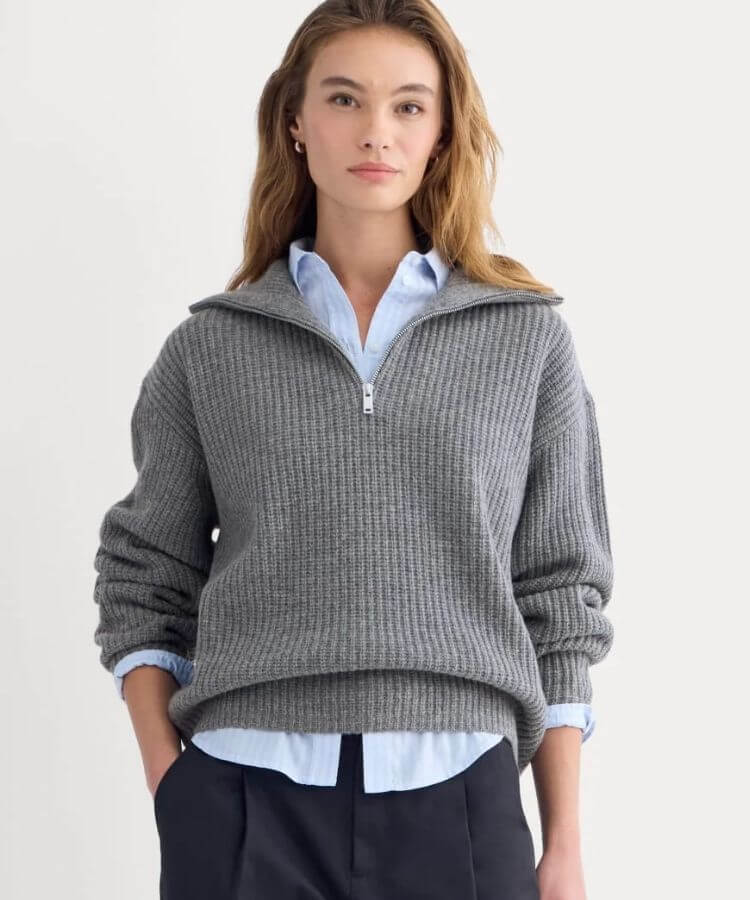 A neutral-toned half-zip sweater with a structured collar.