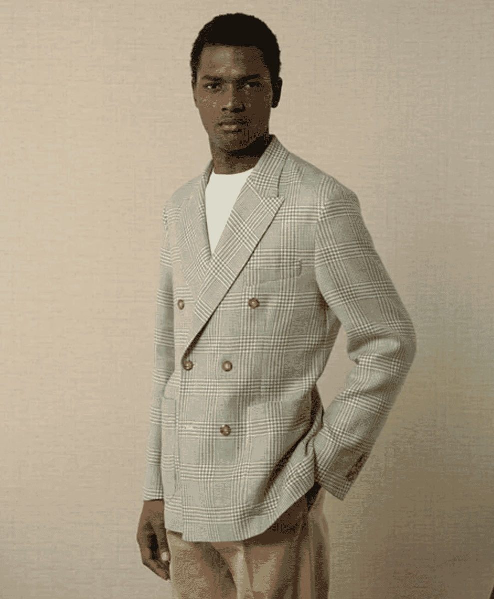 A man modeling a light-colored plaid double-breasted blazer over a white t-shirt.