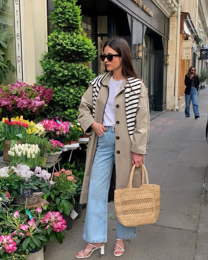 Classic trench coat styled with light wash jeans and a simple white t-shirt.