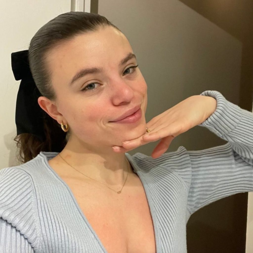 A minimalist flat-lay showing a single tube of sunscreen and a simple lip balm on a neutral background