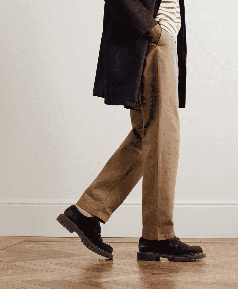Minimalist Common Projects leather sneakers in a professional setting.