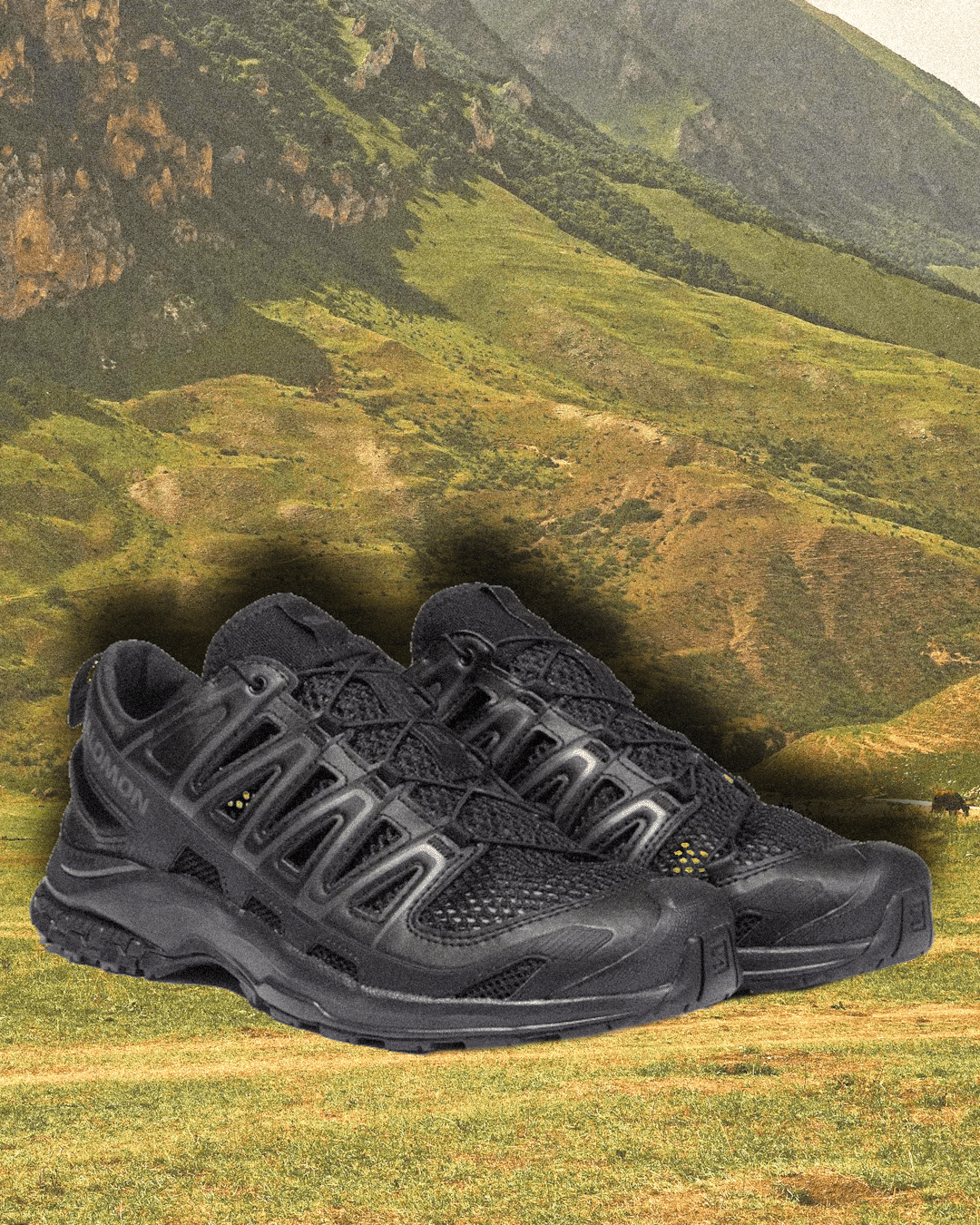 All-black Salomon XA PRO 3D AMPHIB shoes against a rugged background.