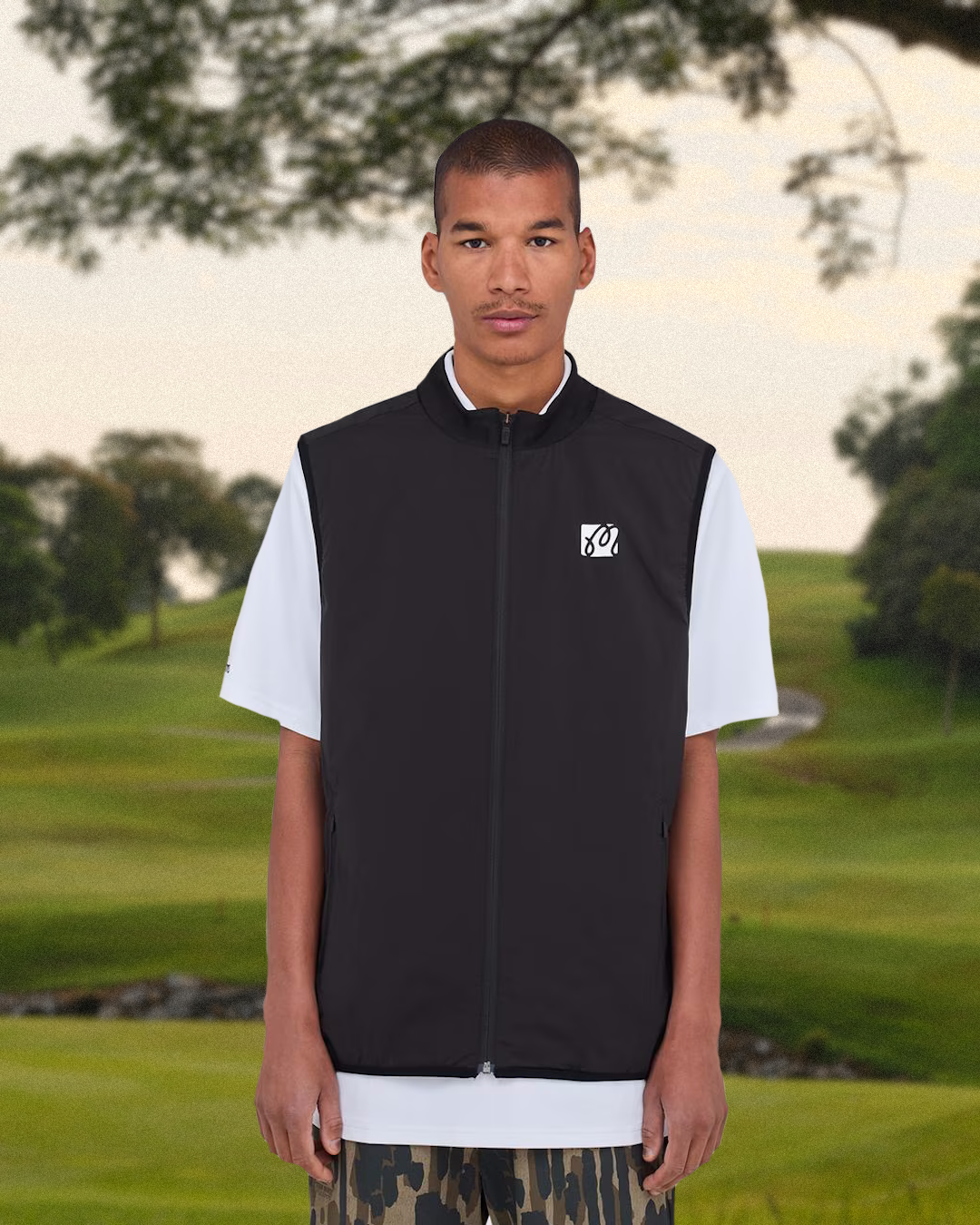 Lifestyle shot of a model in a full 90s golf outfit leaving the course.