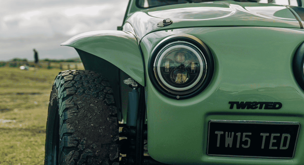 Detailed view of the front of a green customized Defender with 'TWISTED' lettering and off-road components.