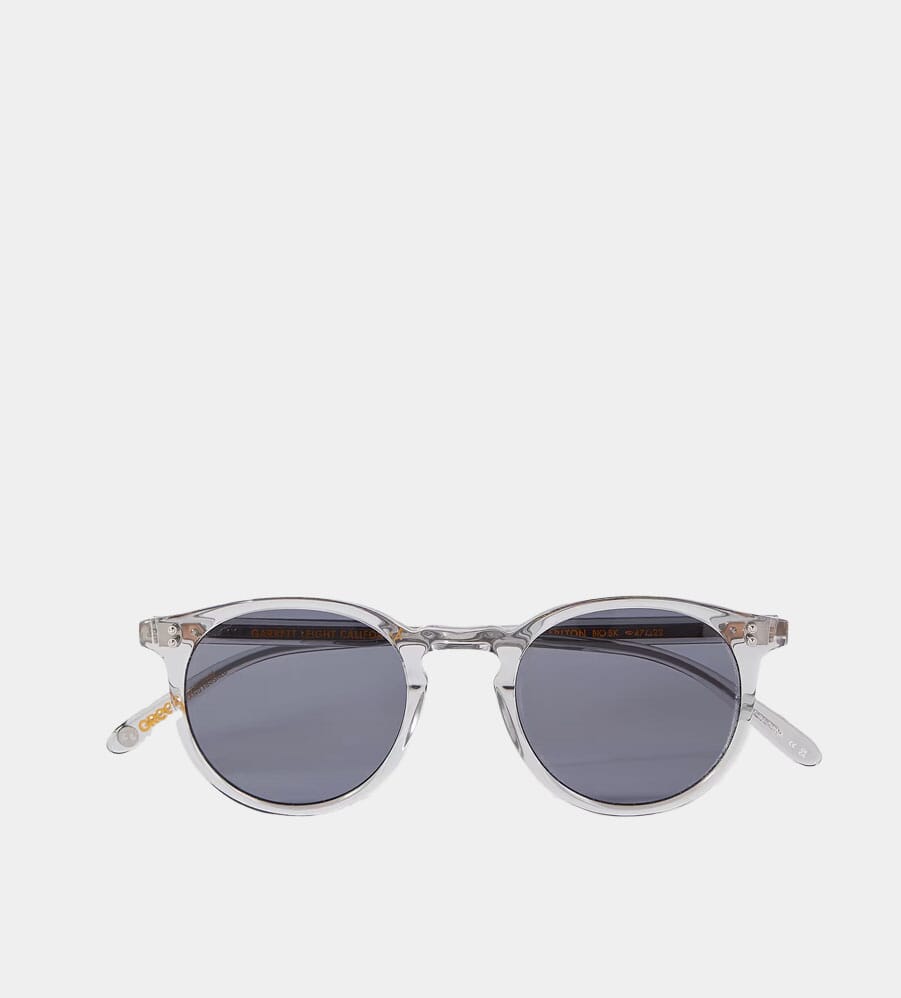 Detailed shot of clear acetate round sunglasses with gray lenses.