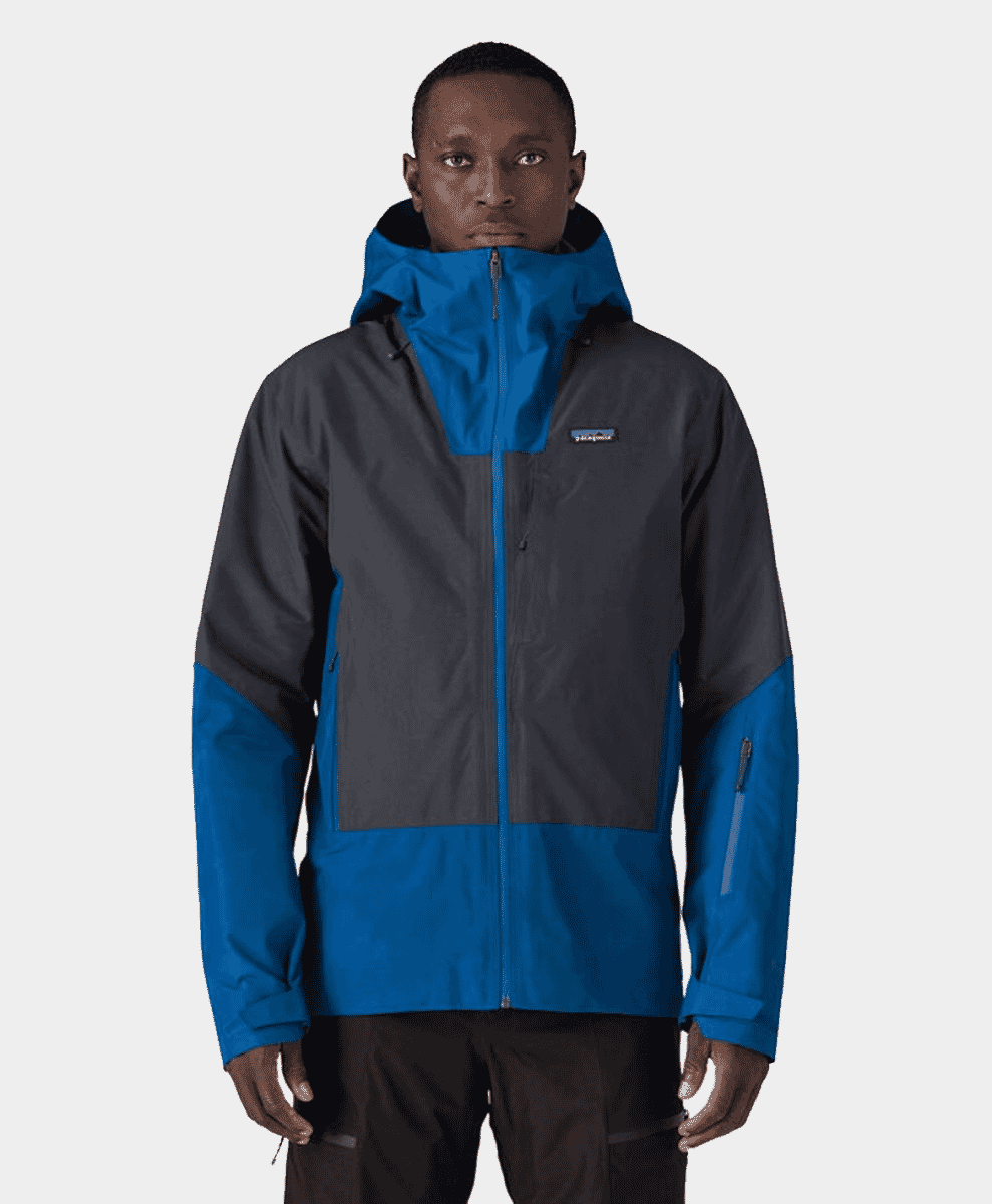 A man modeling a blue and dark gray color-blocked Patagonia jacket.