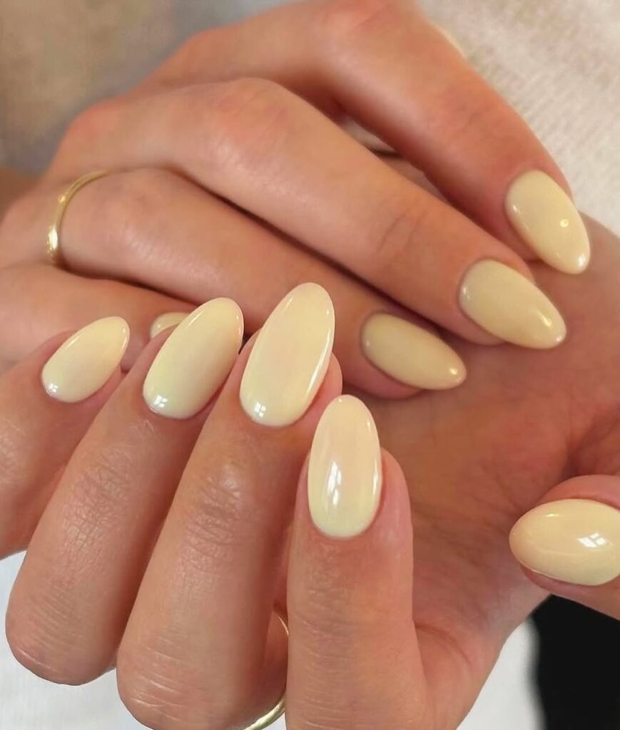 Creamy yellow nails on a deep skin tone.