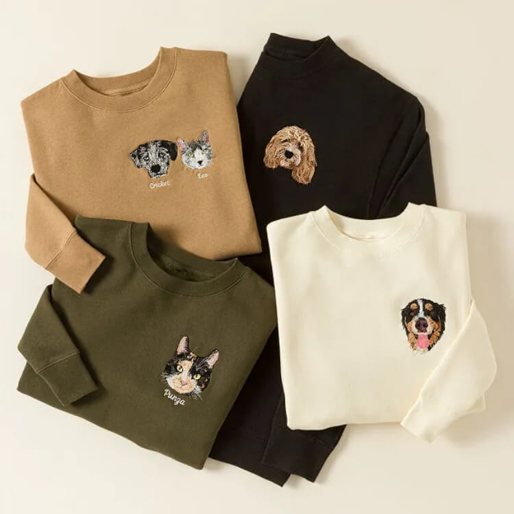 A grey sweatshirt with custom embroidery of a dog's head.