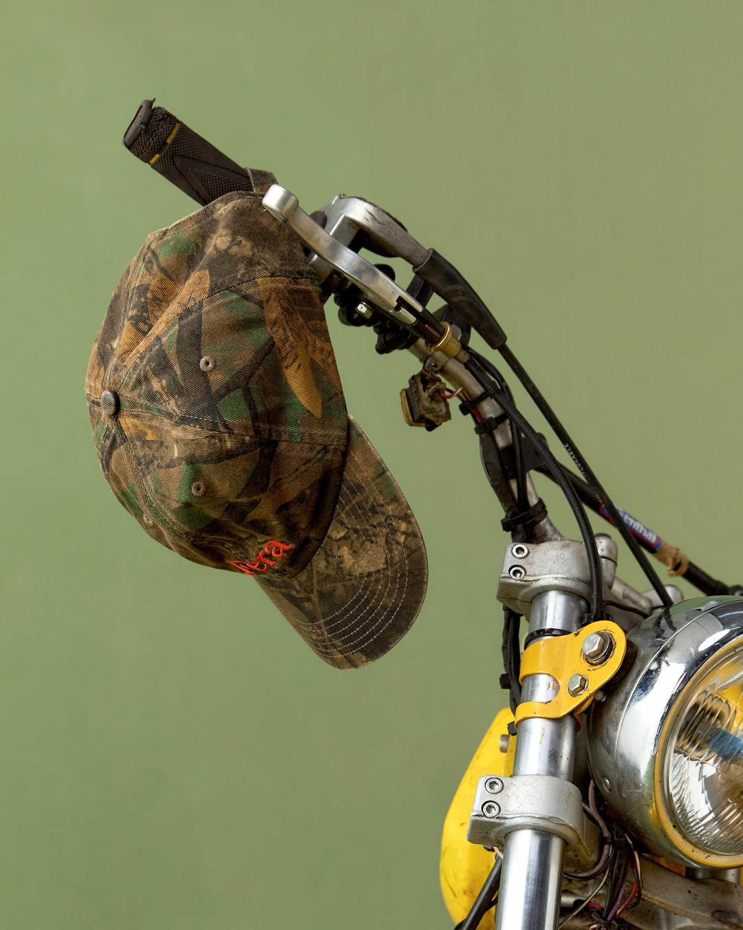 Lower body shot of a person standing in tall grass wearing herringbone denim trousers.