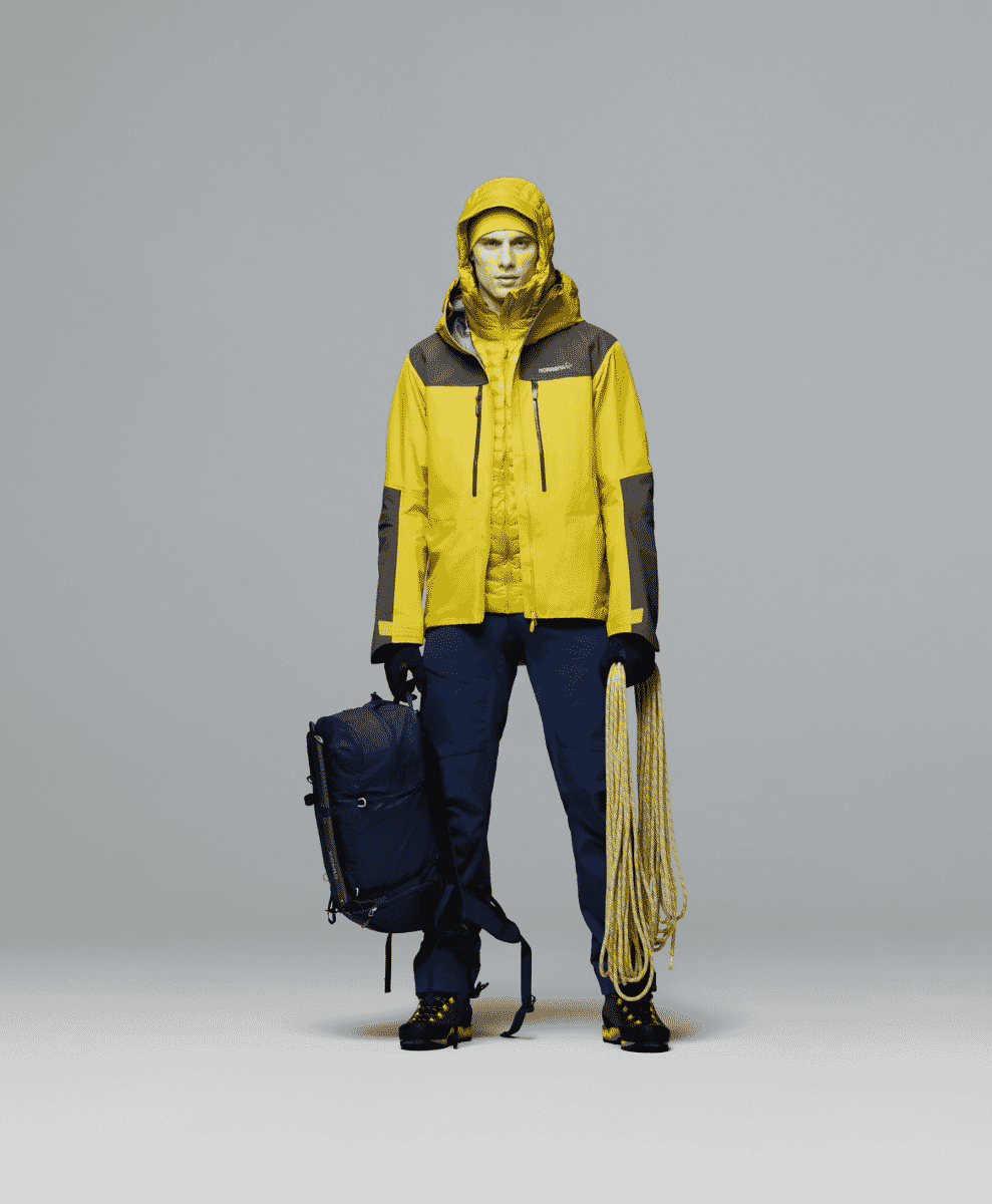 A model in a yellow and dark gray Norrøna mountaineering jacket with climbing rope.
