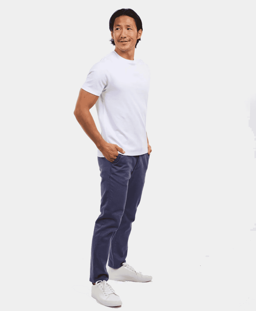 A man in a plain white t-shirt and navy trousers against a white background.